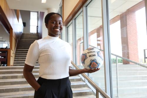 Student poses with soccer ball